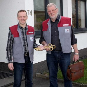 Werner Dreisbach (rechts) übergibt den Schlüssel an seinen Nachfolger Helmut Zacharias (links). Immer dabei übrigens der Schulranzen von Werner Dreisbach, während der Schulzeit und während seines 49-jährigen Arbeitslebens.